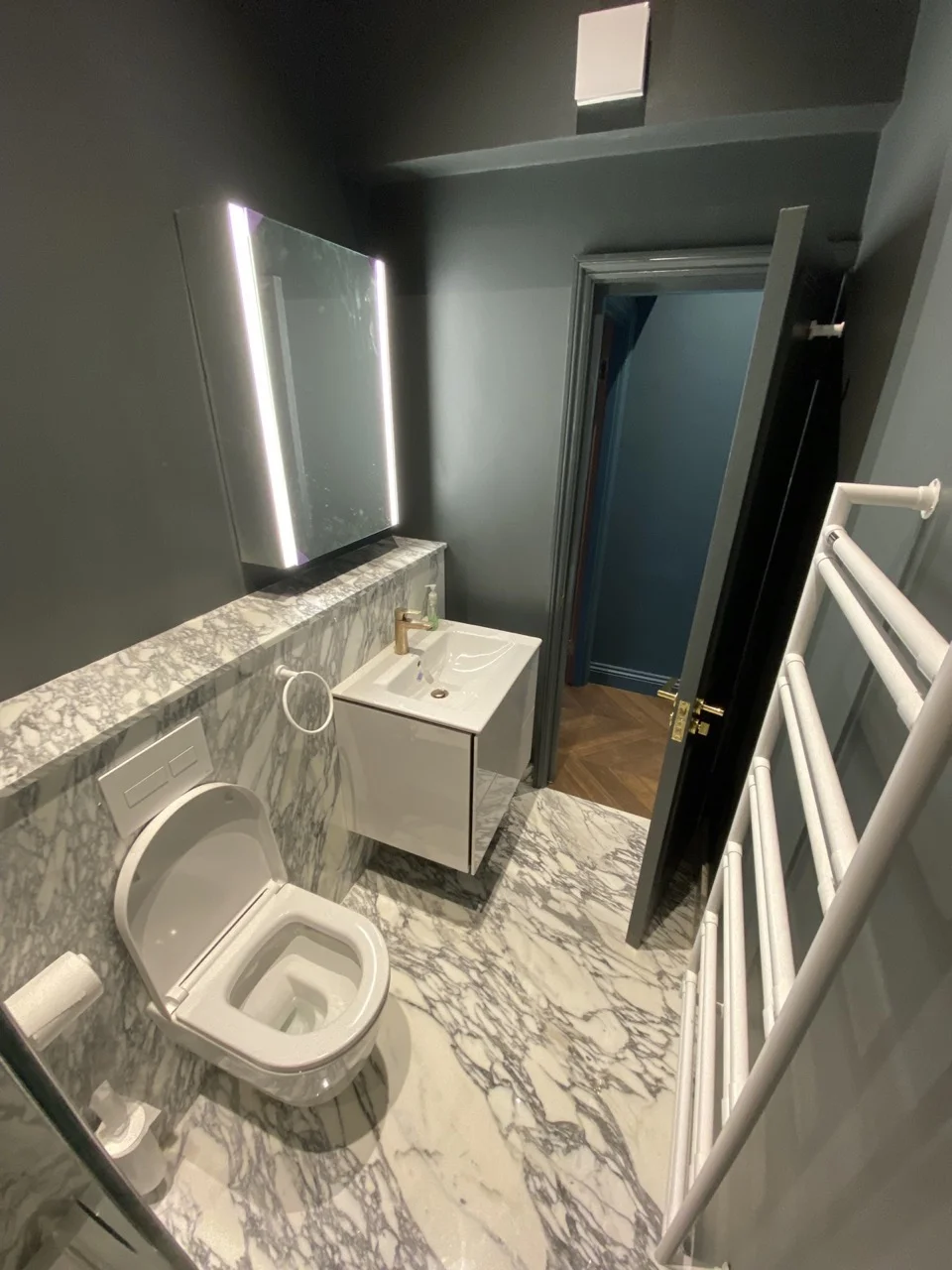 Marble bathroom with backlit mirror: Period Property Renovation in Kensington by Alb Homes