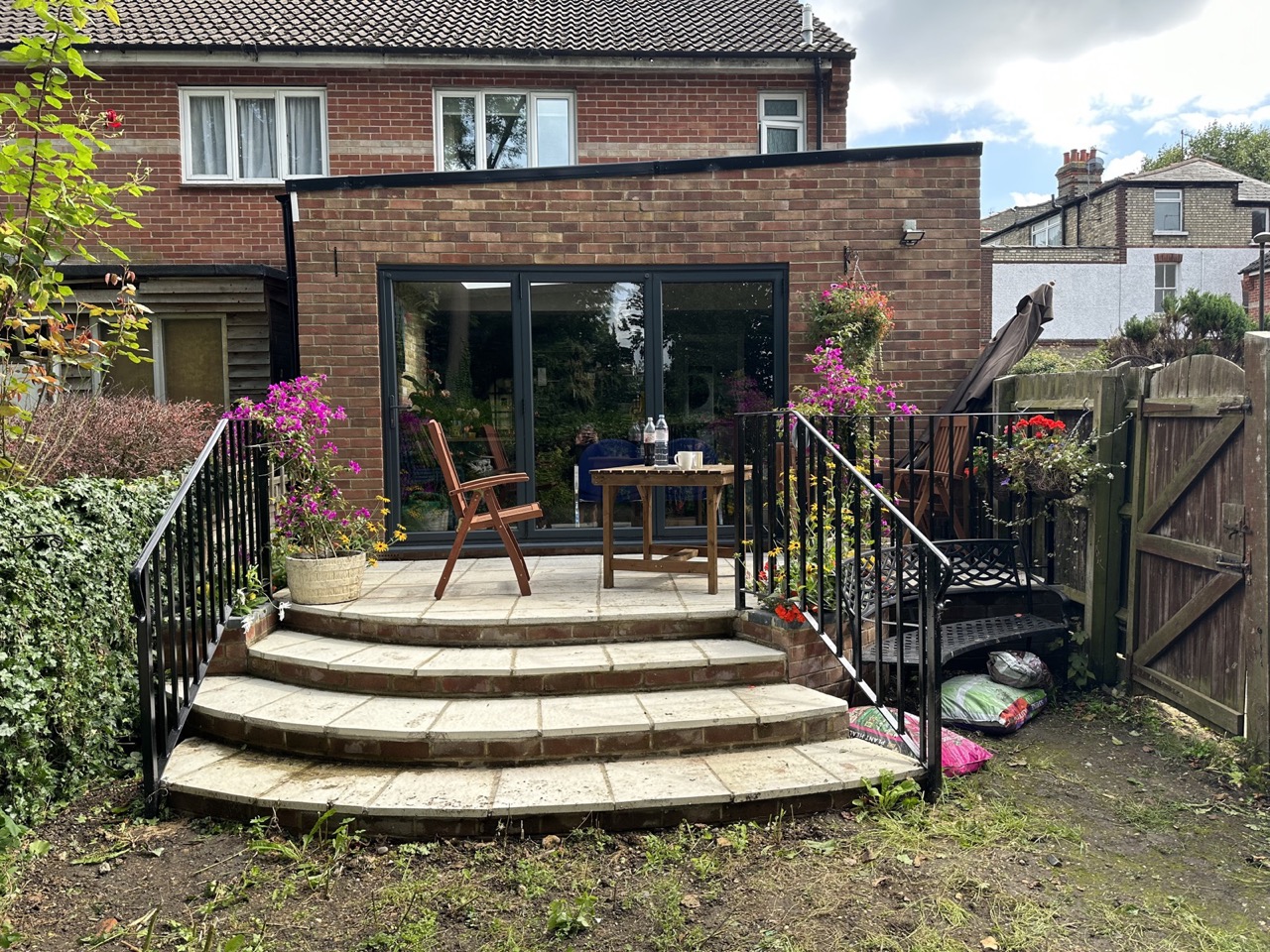 Brick single-storey rear extension with grey bifold doors and planted patio by Alb Homes in Totteridge